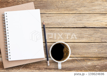 Blank paper notebook,pencil and coffee on brown wooden table background. 139024696