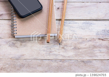 Top view of office desk with blank empty notepad or notebooks on wood table 139024703