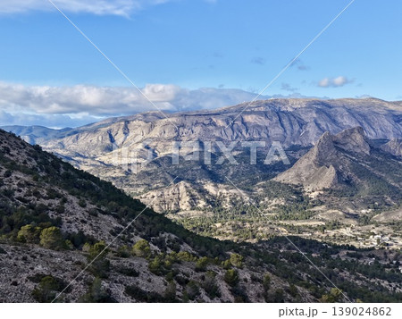 Brightly Illuminated Cliffs And Valleys, Sunlit Canyon With Rugged Cliffs And Distant Mountains 139024862