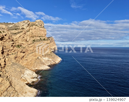 Majestic Cliff Formations Illuminated By Sunlight Create Striking Silhouettes Along Expansive Seashore 139024907