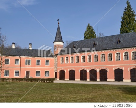 Colorful Structure With Tower And Arches. Bright Pink Front With Corner Tower And Large Windows 139025080