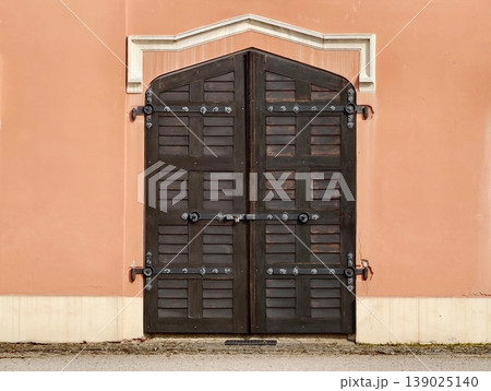 Ancient Doors With Detailed Hardware. Decorative Wooden Doors With Iron Fittings And Textured Surface 139025140