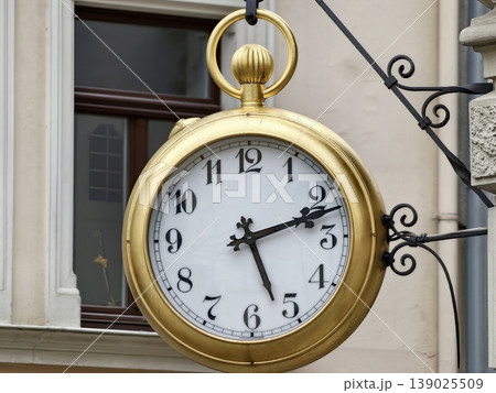 Old City Clock. Retro Enamelfaced Street Clock Enhances Nostalgic Ambiance In Historic Urban Marketplace 139025509