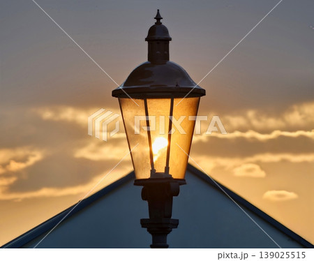 Sunset Illumination With Retro Charm. Oldfashioned Lantern Illuminates Rooftop With Inviting Sunset Glow 139025515