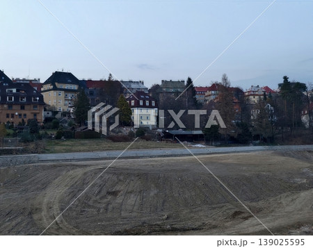 Tranquil Waterfront Town During Twilight Hours. Calm Landscape With Empty Sands And Muted Building Facades Tranquil Waterfront Town During Twilight Hours. Calm Landscape With Empty Sands And Muted Building Facades 139025595