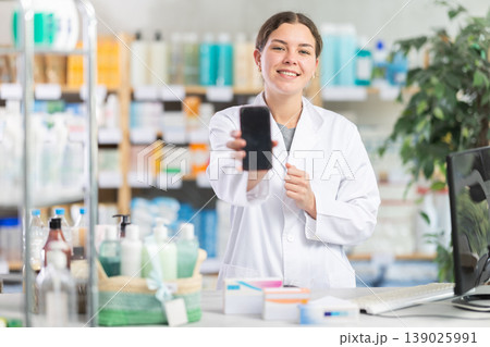 Female pharmacist holding mobile phone 139025991
