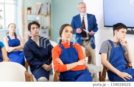 Young students in blue overalls attending technical seminar 139026028