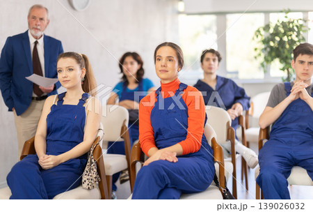 Young students in blue overalls attending technical seminar 139026032