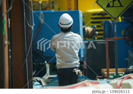 工事現場で働く男性作業員の後姿 工事現場で働く男性作業員の後姿 139026111