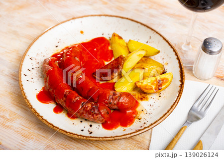 grilled sausages and slices of toasted potatoes grilled sausages and slices of toasted potatoes 139026124