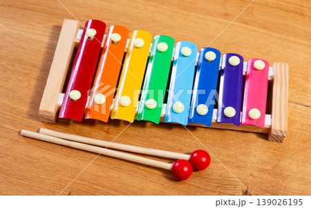 Children multi-colored xylophone with sticks on wooden background Children multi-colored xylophone with sticks on wooden background 139026195
