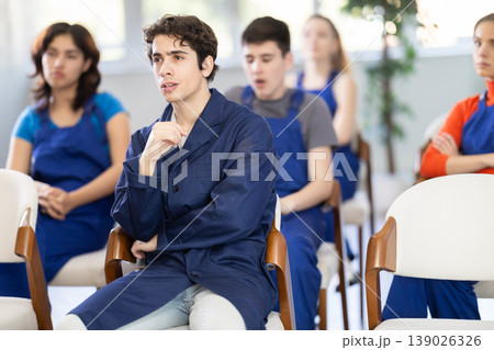 Young boy in blue overalls attending educational seminar in auditorium Young boy in blue overalls attending educational seminar in auditorium 139026326