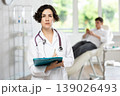 Portrait shot of female doctor holding clipboard in hand while standing in medical esthetic clinic 139026493