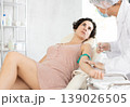 Male anesthesiologist injecting anesthetic into vein on her arm with syringe in cosmetology clinic 139026505