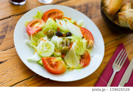 Salad with chopped tomatoes, sliced lettuce, cucumber and olives Salad with chopped tomatoes, sliced lettuce, cucumber and olives 139026526