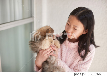 家で可愛いポメラニアンの子犬と遊んでいる女子中学生の様子 139026618