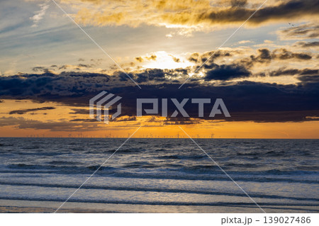 Ocean sunset with offshore wind turbines on horizon renewable energy and sustainable future concept Ocean sunset with offshore wind turbines on horizon renewable energy and sustainable future concept 139027486