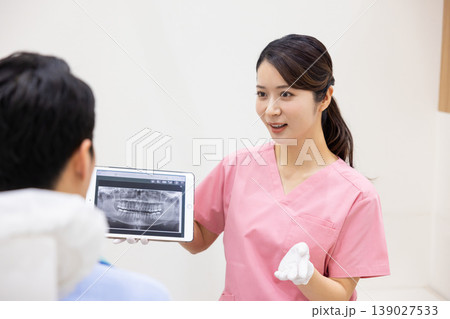 歯科医　タブレットを見せながら説明する歯科医 139027533