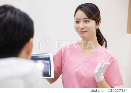 歯科医　タブレットを見せながら説明する歯科医 139027534