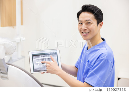 歯科医 タブレットを見せながら説明する歯科医 歯科医 タブレットを見せながら説明する歯科医 139027538