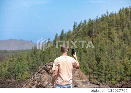 Man Taking Photo with Smartphone on Mountain Viewpoint Travel Adventure Scene 139027765