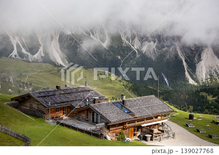 Cozy wooden mountain chalet in the Dolomites, Italy, surrounded by alpine landscape in summer.  139027768