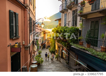 Family Walking Down Scenic European Old Town Street at Sunset with Lake View 139027795