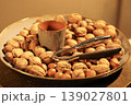 Decorative bowl filled with walnut and hazelnut placed on a stylish table.  139027801