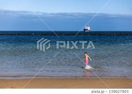 Active Boy Running In Sea Water Near Sandy Beach On Sunny Summer Day 139027803