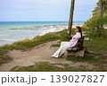 Young Woman Relaxing On Coastal Path Bench With Ocean View Background 139027827