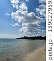 City skyline view from a sandy sea beach under dramatic cloudy sky 139027959