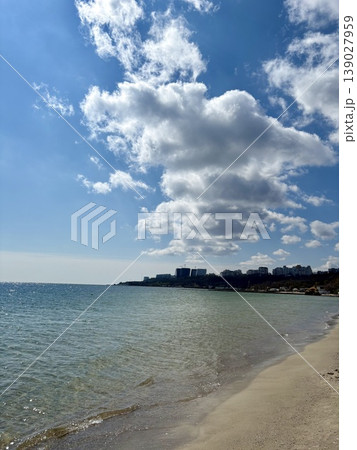 City skyline view from a sandy sea beach under dramatic cloudy sky City skyline view from a sandy sea beach under dramatic cloudy sky 139027959
