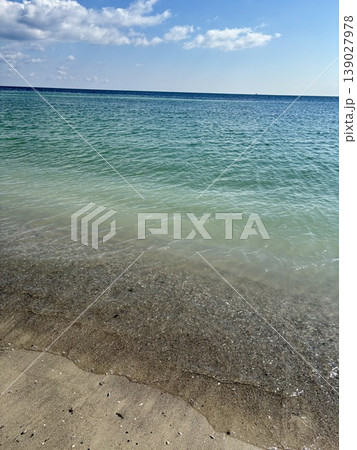 Beautiful turquoise sea water with small waves on a sandy beach Beautiful turquoise sea water with small waves on a sandy beach 139027978