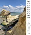 Massive Rocks on a Sunny Sea Coast with Clear Water and Blue Sky 139027995
