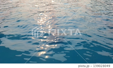 Sunlight Reflection on Calm Blue Water Surface Creating Sparkling Natural Background Sunlight Reflection on Calm Blue Water Surface Creating Sparkling Natural Background 139028049