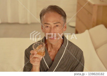 寝室でウイスキーを飲むシニア男性　ポートレート　カメラ目線 139028182