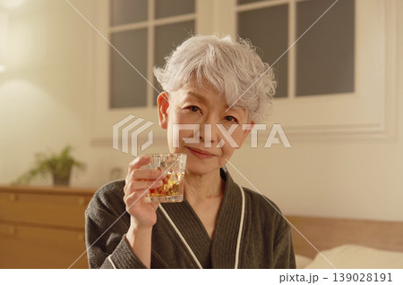 寝室でウイスキーを飲むシニア女性 139028191