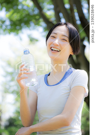 新緑の屋外で水分補給をする女性の横顔ポートレート ウォーキングやランニングの運動やスポーツの 新緑の屋外で水分補給をする女性の横顔ポートレート ウォーキングやランニングの運動やスポーツの 139028646