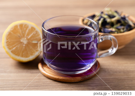 Hot butterfly pea tea in glass cup with lemon and dried flowers Hot butterfly pea tea in glass cup with lemon and dried flowers 139029033