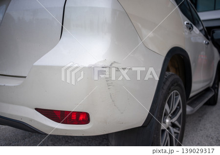 White SUV with visible rear bumper scratch and damage close up 139029317