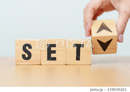Hand change wooden block with SET text or The Stock Exchange of Thailand to UP and Down arrow symbol icon. decrease and increase, price, stocks, financial, trade, value and Cut loss concept 139030261