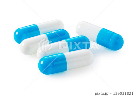 白背景に山盛りになった青と白のカプセル剤。医療やサプリメントのイメージ素材。 139031821