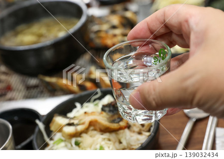 clear korean distilled spirit soju in a small glass 139032434