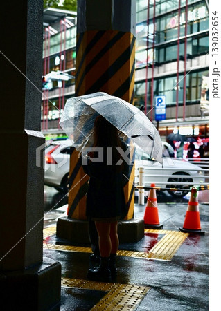 雨上がりの都会 傘を差して信号を待つ人とガード下の光景 139032654