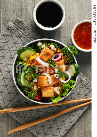 Bowl filled with mixed greens, crispy tofu, and sauces on side Bowl filled with mixed greens, crispy tofu, and sauces on side 139033261