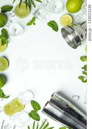 Limes, mint leaves, and glassware are arranged on a backdrop 139033286
