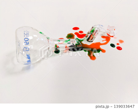 A broken Erlenmeyer flask and spilled chemicals create a striking visual of a science experiment gone wrong 139033647