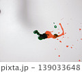 Green And Red Paints Blending Into Organic Shape Across White Background, Viscous Droplets And Delicate Trails 139033648