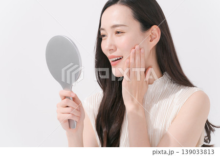 鏡をチェックしてスキンケアをする女性 139033813
