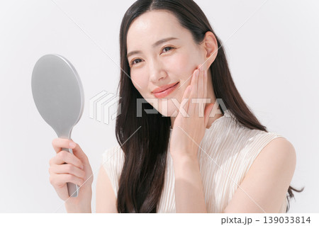 鏡をチェックしてスキンケアをする女性 鏡をチェックしてスキンケアをする女性 139033814
